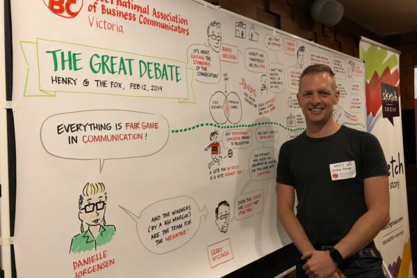 Matthew Magain stands next to his capture of the IABC Victoria Great Debate